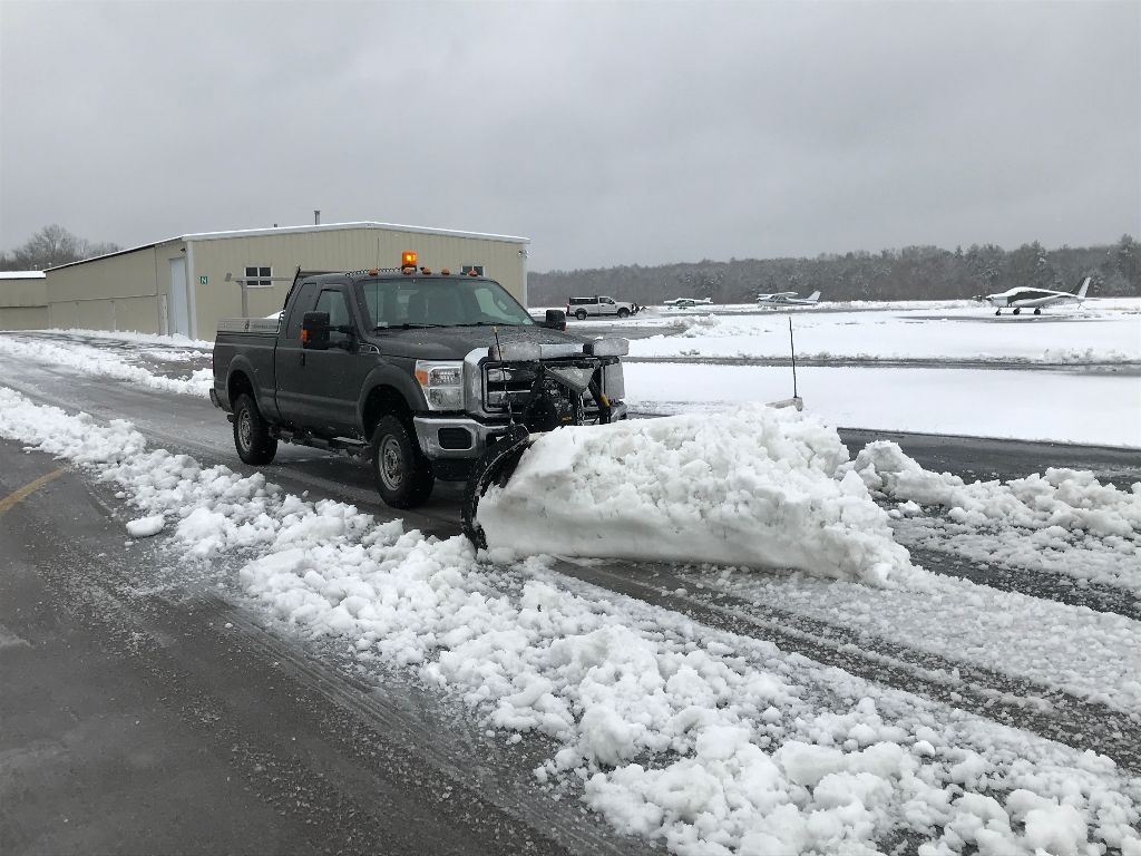 A pickup truck plowing snow on the road
