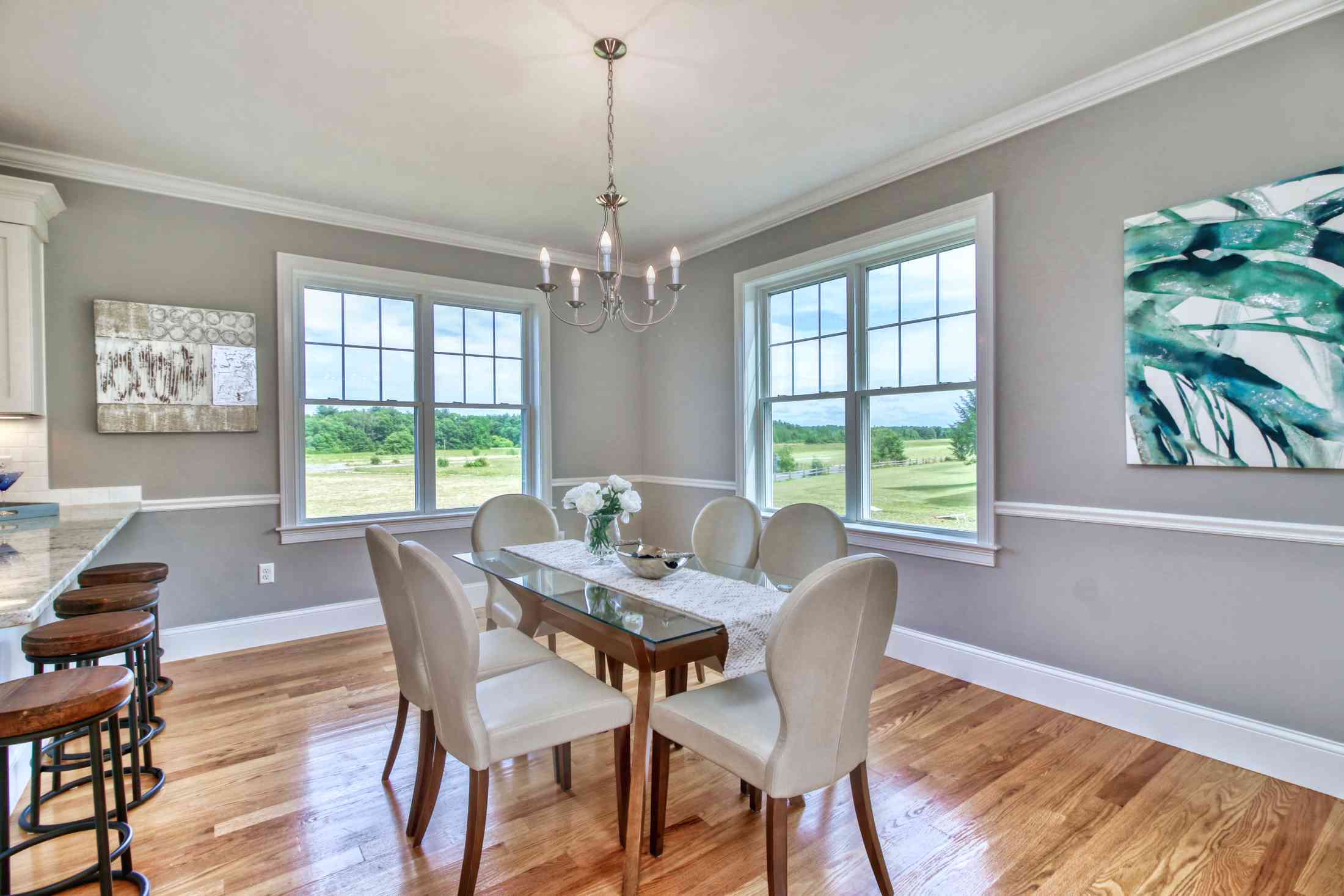 Pastel grey dining room with a dining set and a counter top with barstools