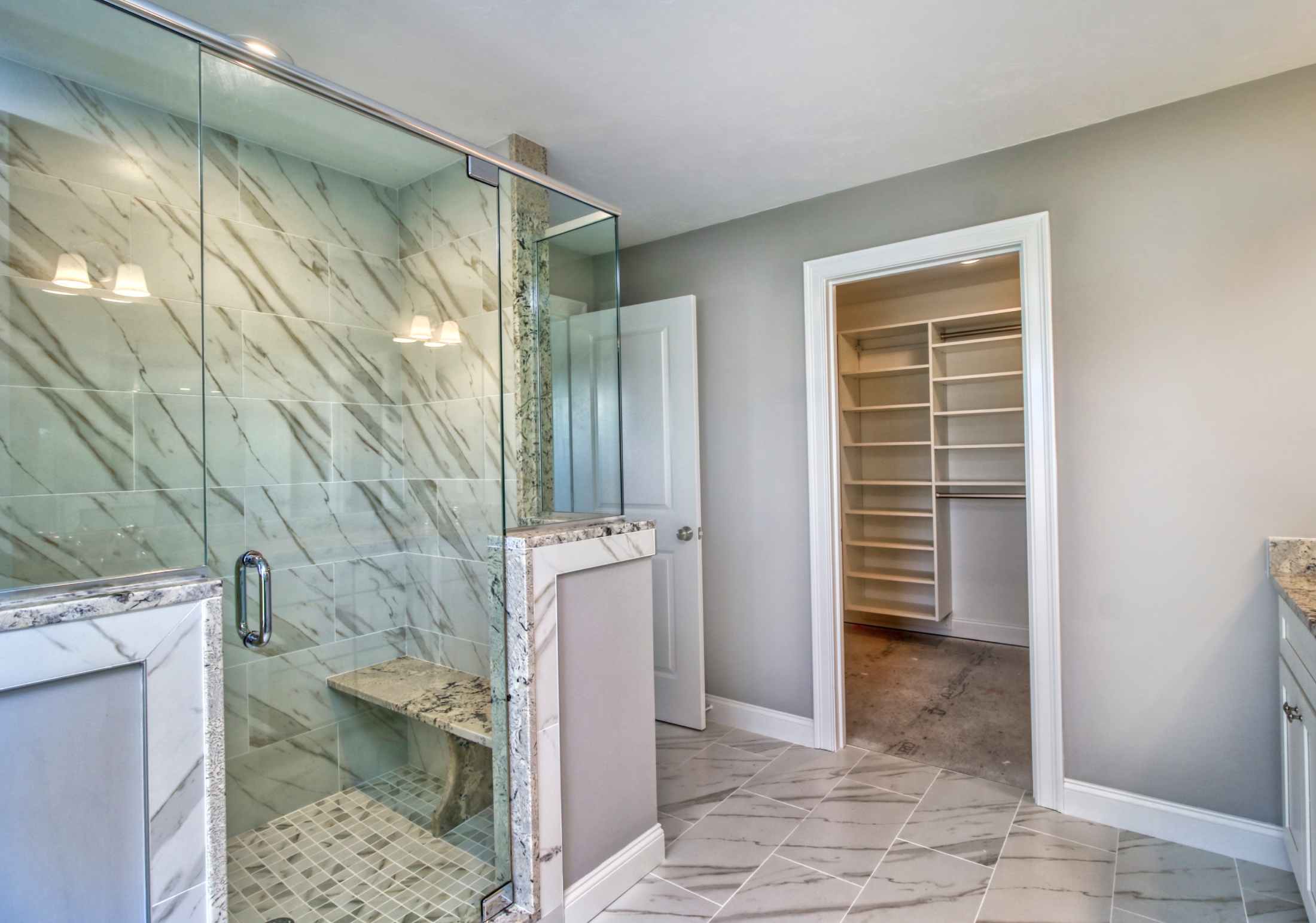 Paste grey bathroom with white accents and glass shower door and walls