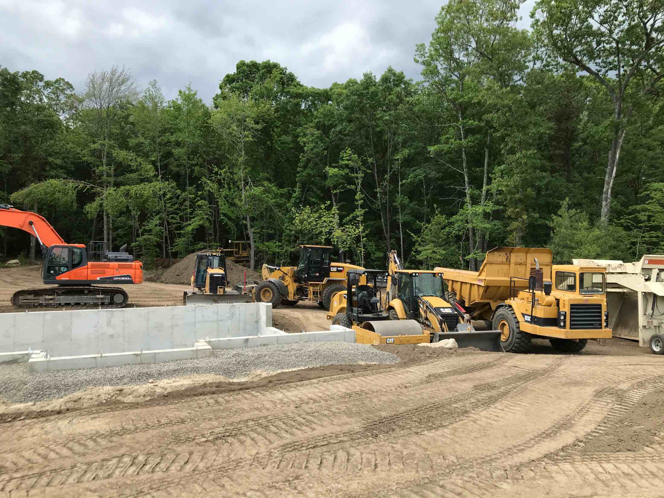 Six construction equipment trucks working on a construction site